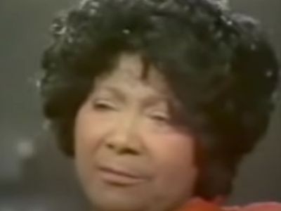 Mahalia Jackson has got a short curly black hair in the picture.